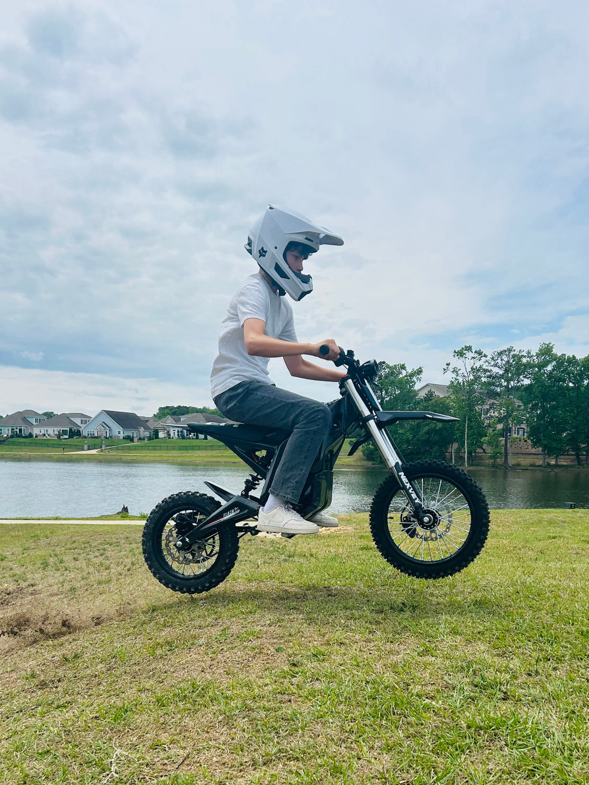 NEXVEY Flash Black electric dirt bike jumping beside a lake