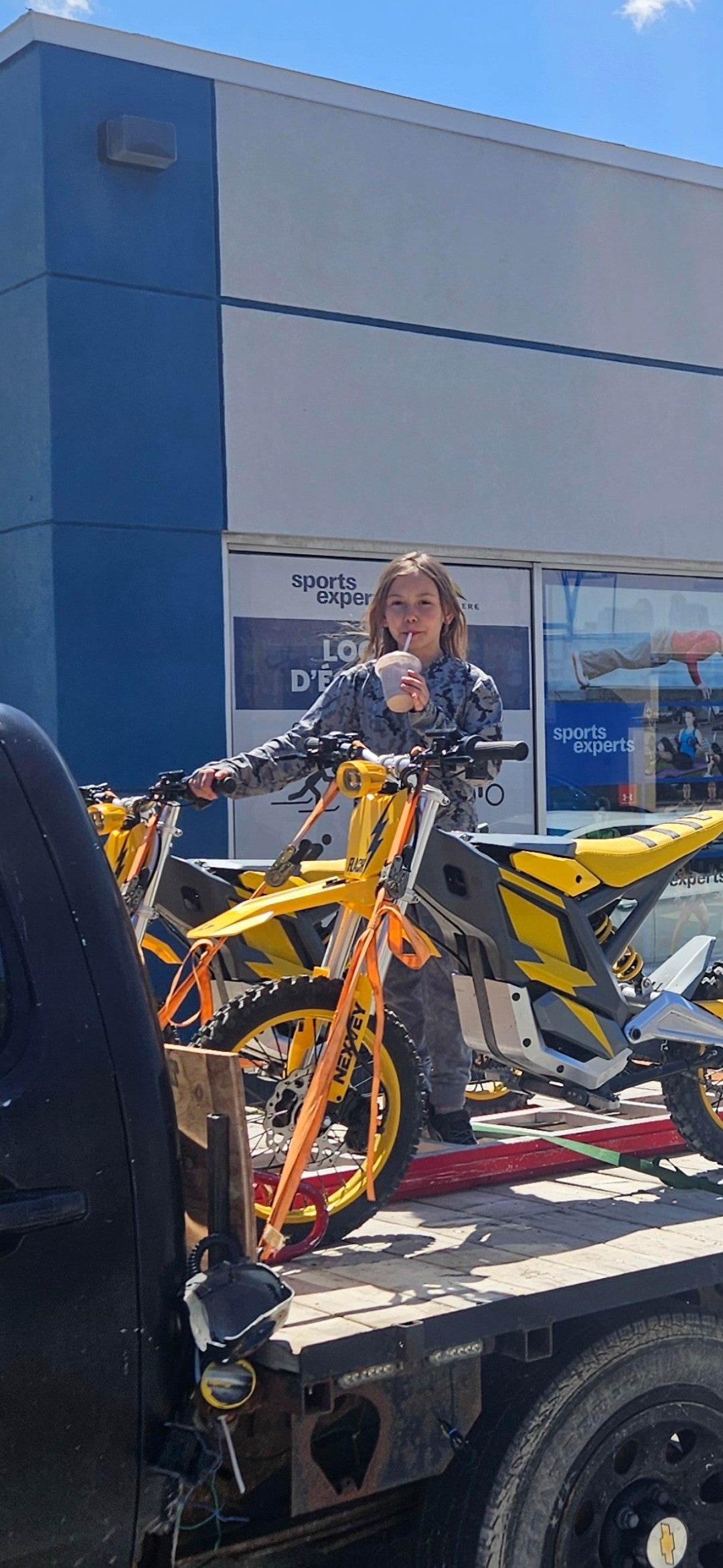 Yellow NEXVEY Flash electric dirt bike loaded on a pickup truck