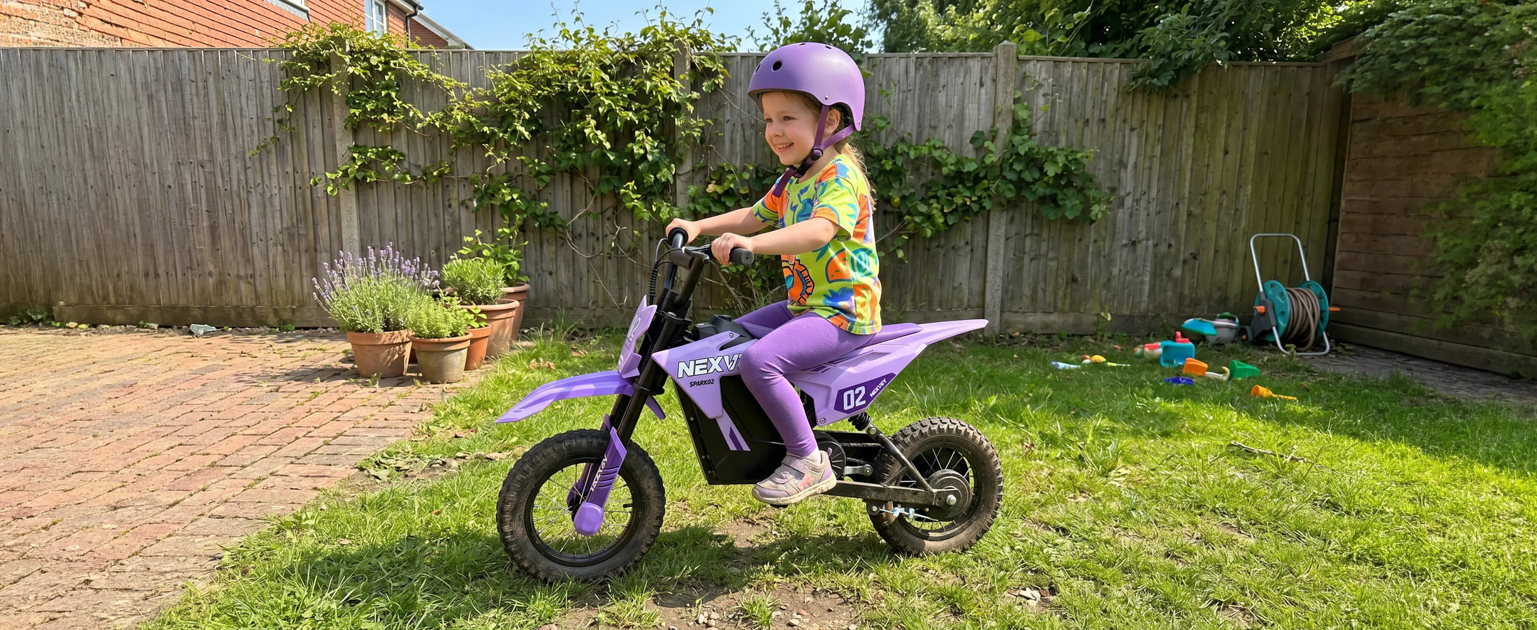 Child riding a purple NEXVEY Spark 02 electric dirt bike in a backyard