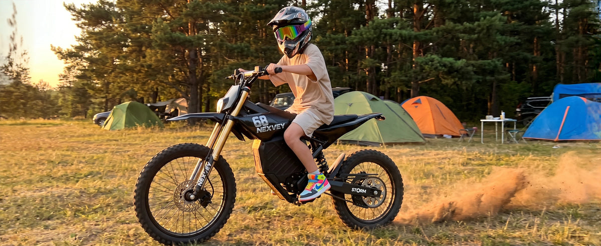 Rider on a NEXVEY Storm electric dirt bike at a campsite