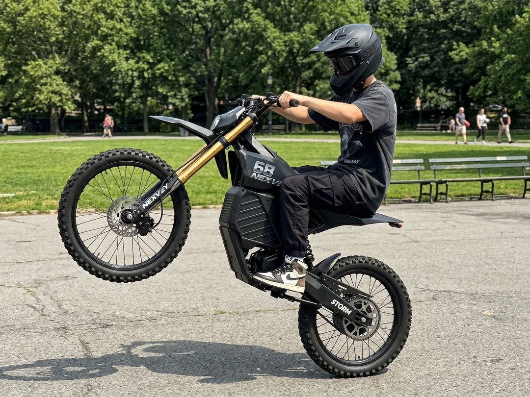 Rider performing a wheelie on a NEXVEY Storm electric dirt bike