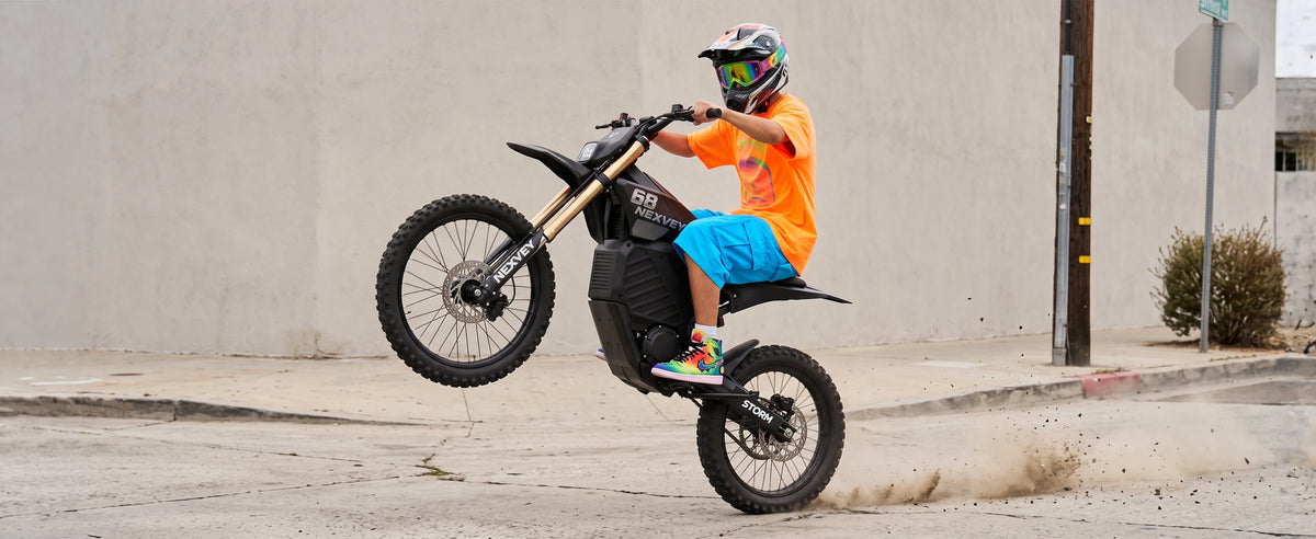 Rider performing a wheelie on a NEXVEY Storm electric dirt bike