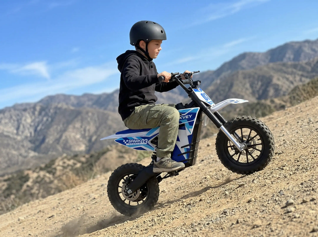 Young rider on a Nexvey Spark 03 electric dirt bike with pneumatic tires, climbing a steep off-road hill